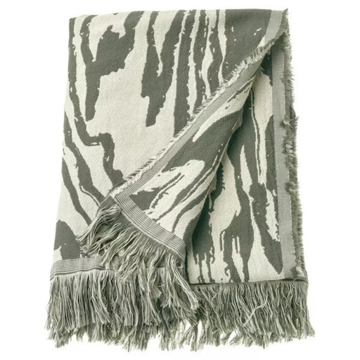 Neatly folded IKEA TANDMOTT Throw, a chic and versatile blanket for adding comfort and charm to any space