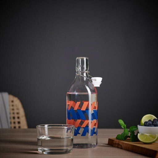 An elegant clear glass bottle with a stopper, designed for displaying beverages, available at IKEA.