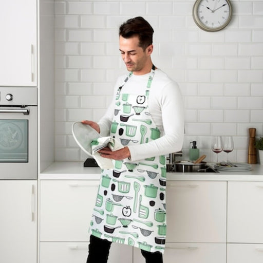 A man wearing an apron and cleaning a plate 10476455