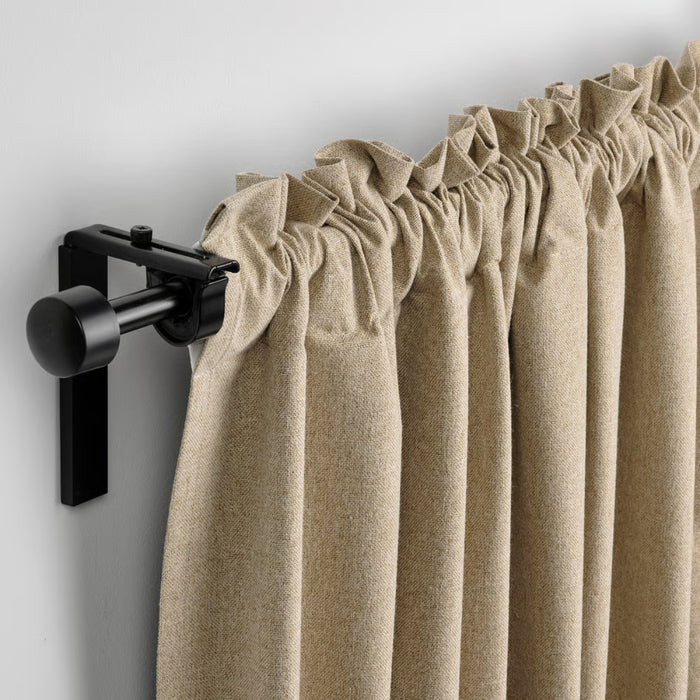 Beige curtain with a black curtain rod on a white background