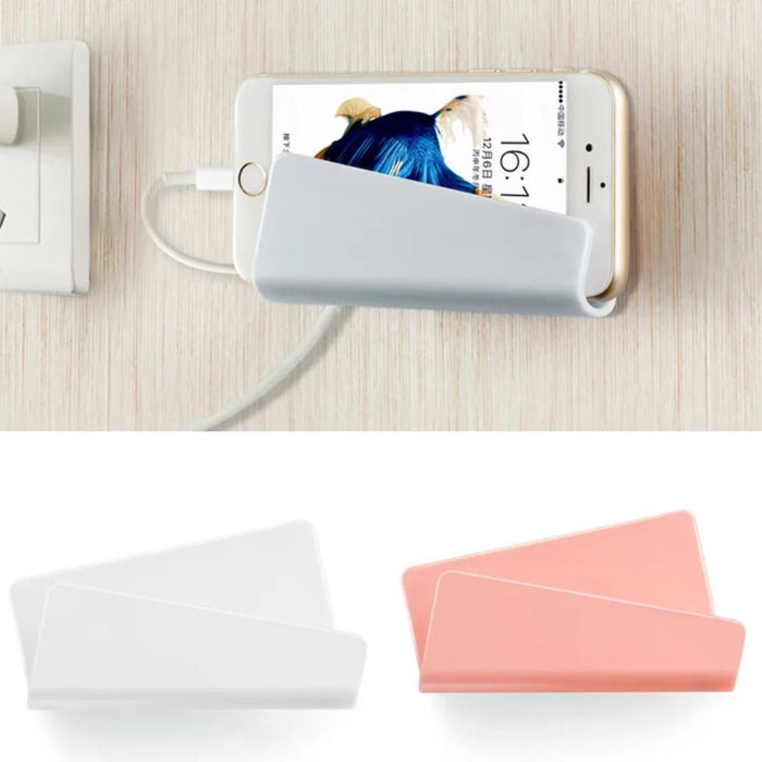 Phone with a charging cable and two phone cases on a light wooden surface.