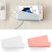 Phone with a charging cable and two phone cases on a light wooden surface.