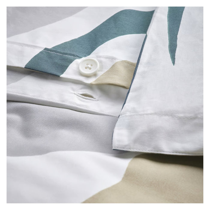 Close-up of a white shirt with blue accents and a button, on a light gray background.