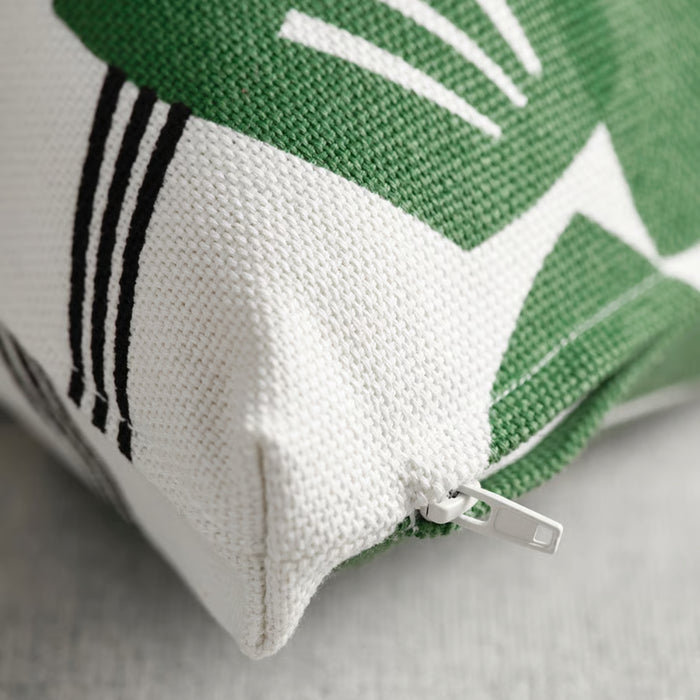 Close-up of a green and white fabric with a zipper on a gray surface