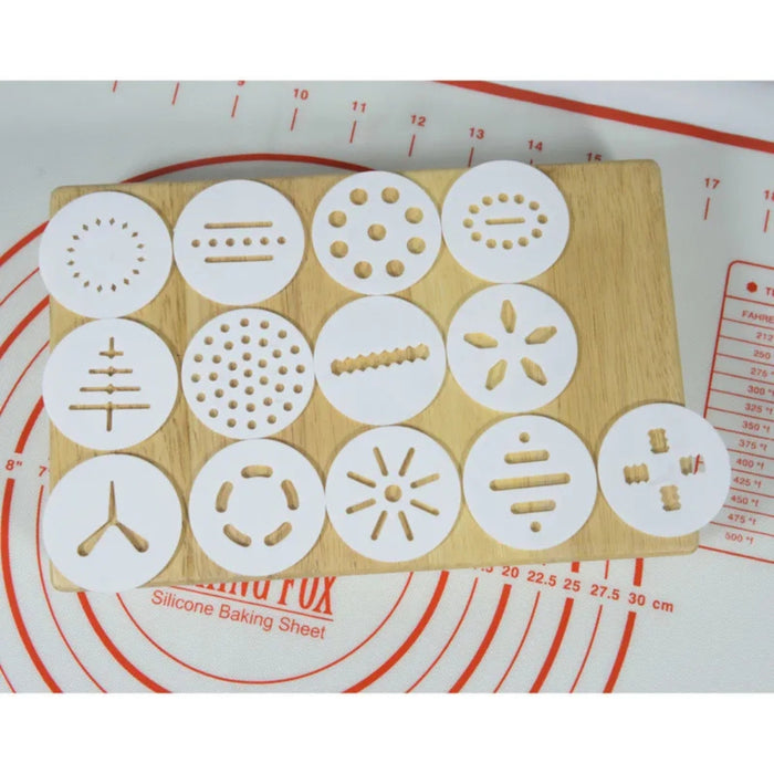 Set of silicone cookie stamps on a wooden board with a measuring wheel in the background.