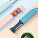 Colorful kitchen tools on a light blue surface with a bowl of green tea.