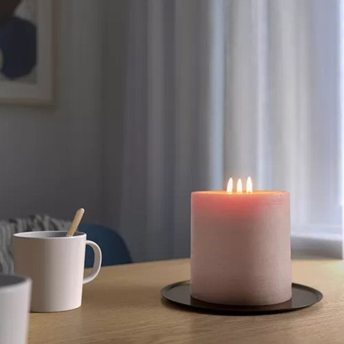 An unscented block candle from IKEA, emitting a warm and inviting glow that creates a cozy atmosphere in any room