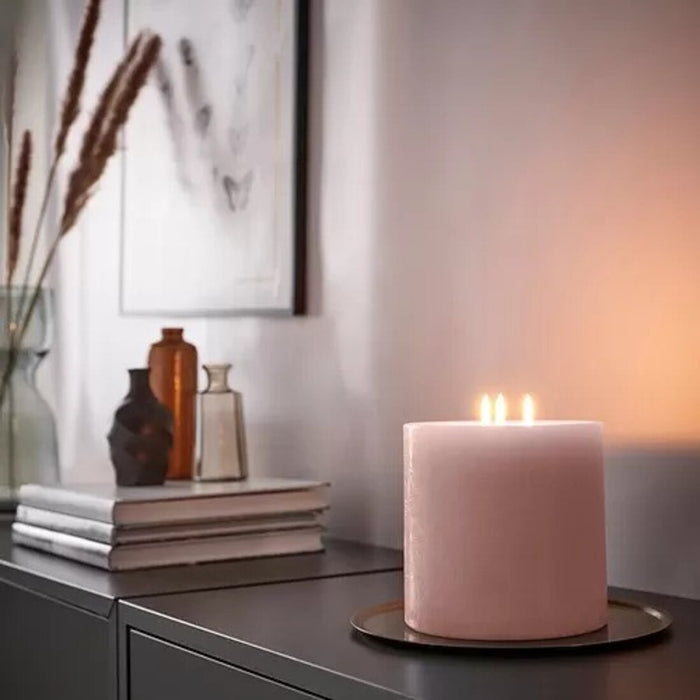 An unscented block candle from IKEA, emitting a warm and inviting glow that creates a cozy atmosphere in any room.