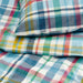 Colorful plaid fabric with a mix of blue, green, red, and yellow patterns.