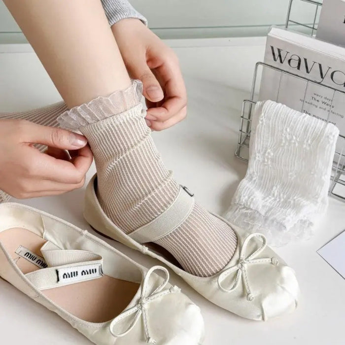 Person wearing beige ankle socks with white shoes on a light background