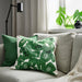 Green and white patterned pillow on a gray sofa with a neutral background