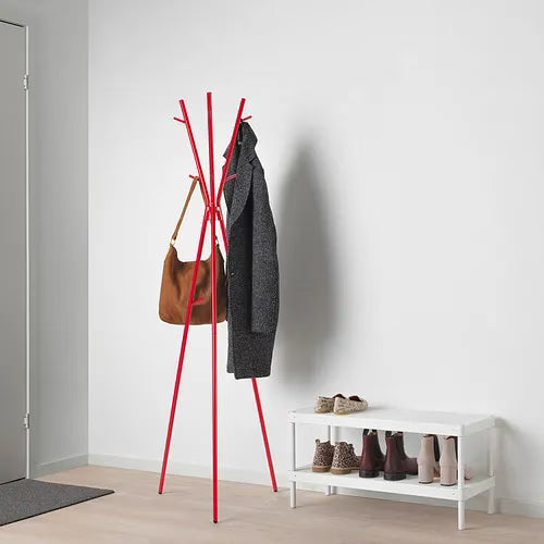 Close-up of IKEA EKRAR coat stand hooks holding jackets and bags in red finish