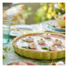 Pink pie with decorative elements on a floral tablecloth