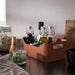 Ceramic tray with various kitchen items including bottles and jars on a wooden surface.