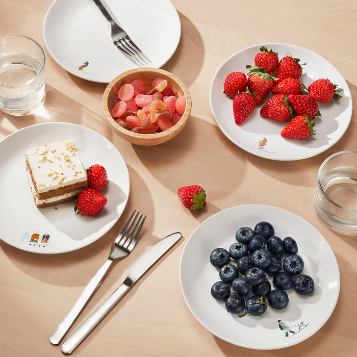  IKEA SPJUTLILJA patterned plates styled with assorted fruits and cake on a dining table