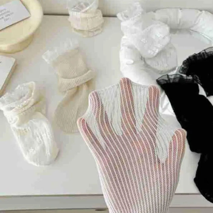 Collection of baby socks and booties on a white surface