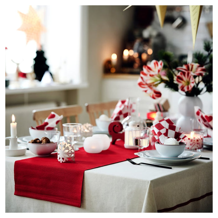Festive table setting featuring the white and red VINTERFINT bowl used for serving snacks alongside holiday decor.