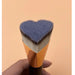 Digital Shoppy  Heart-shaped makeup brush with gold ferrule and black handle held against peach background