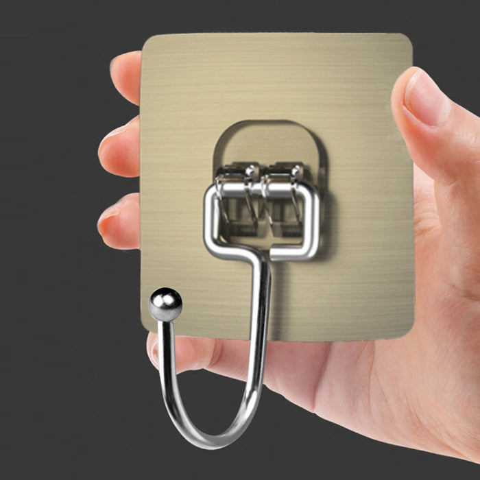 Hand holding a metallic hook on a dark background
