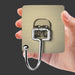 Hand holding a metallic hook on a dark background