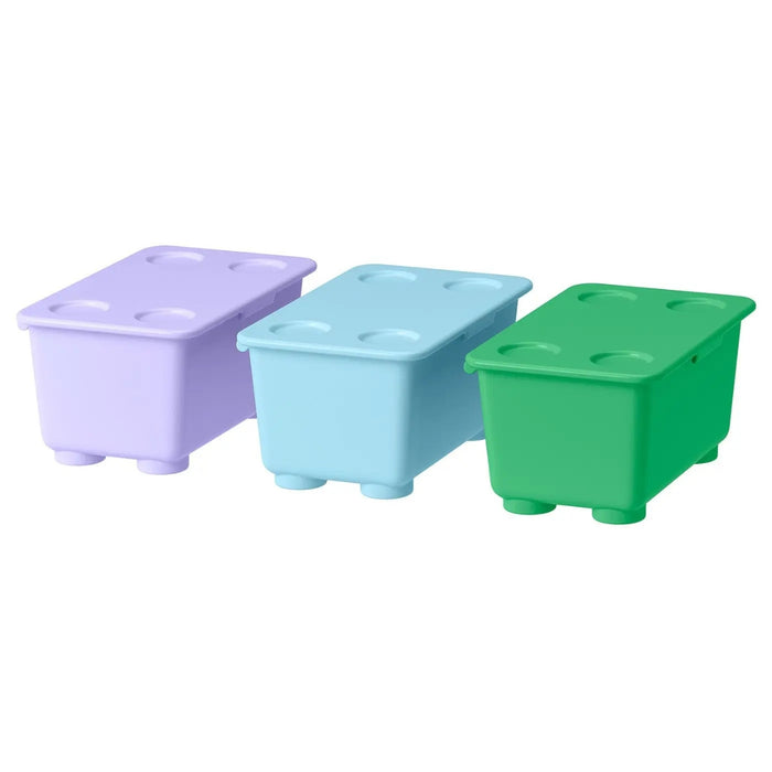 Three IKEA GLIS storage boxes in green, light purple, and blue, styled like oversized LEGO bricks with studded lids