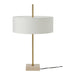 Table lamp with white shade, gold stem, and beige base on a white background