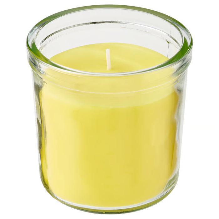 Yellow candle in a clear glass jar on a white background