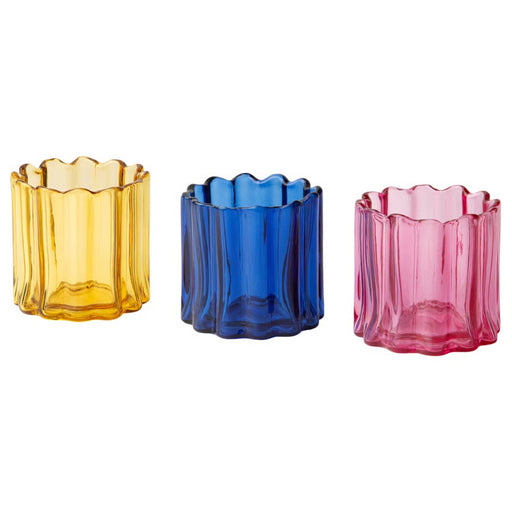 Three colorful glass candle holders on a white background