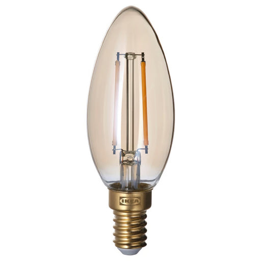 IKEA light bulb with clear glass and brass base on a white background