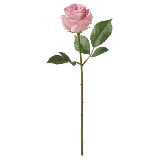 Pink artificial rose with green leaves on a white background