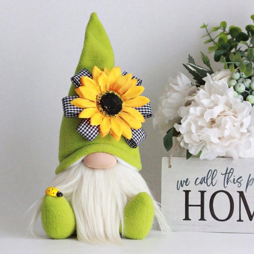Green gnome with a sunflower hat next to a decorative sign with flowers on a white background