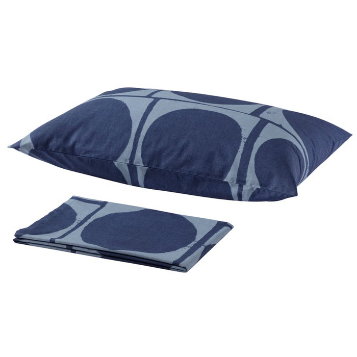 Blue patterned pillow and folded blanket on a white background