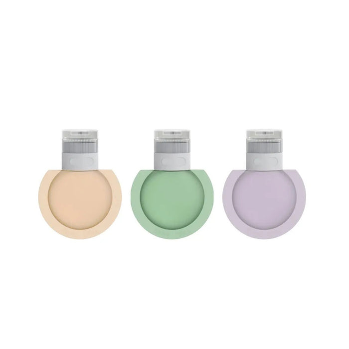 Three pastel-colored bottles with caps on a white background