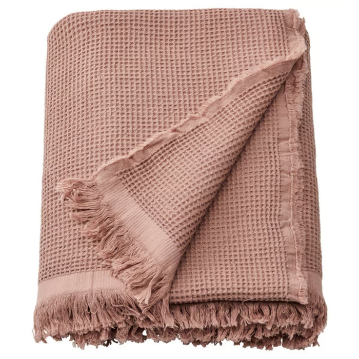 KLOTSTARR throw, pale pink, 130x170 cm – waffle-textured cotton blend with fringed edges, partially folded on white surface. Dyed using beetroot residue – 50562031.
