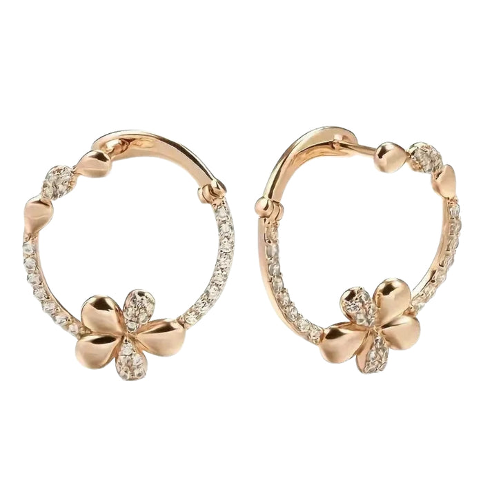 Rose gold hoop earrings with clover designs on a white background