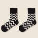 Pair of ink black fleece-lined socks with bold white zigzag pattern laid flat