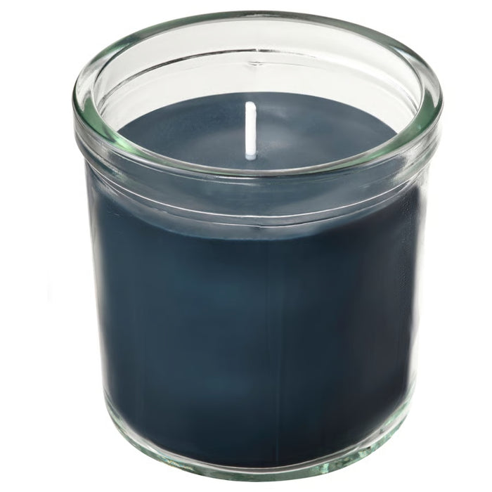 Dark blue candle in a clear glass jar on a white background