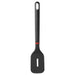 A black kitchen spatula with a rectangular head and a single elongated slot, featuring a dark gray handle with a red accent near the joint, resting on a light gray surface