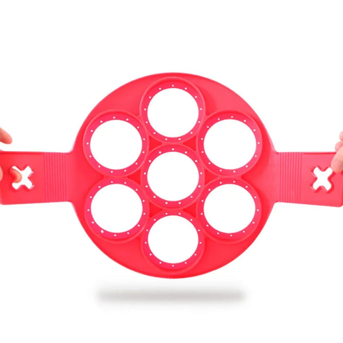 7-hole Silicone Non-Stick Pancake Egg Mould in vibrant red, featuring seven evenly spaced circular cavities and side handles with cross-shaped cutouts—designed for making perfectly round pancakes or eggs simultaneously, ensuring even cooking and easy flipping. Ideal for stovetop or griddle use -2147192 13025440.