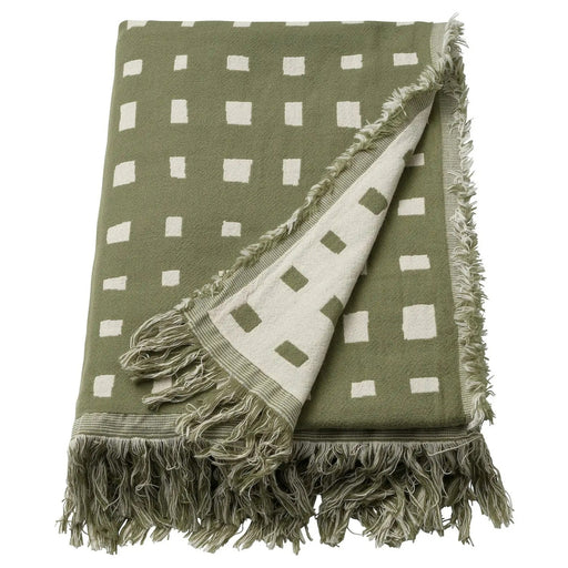 IKEA SVARTTÅG throw blanket in grey-green with white square grid pattern and fringe edges, folded to show reversible design