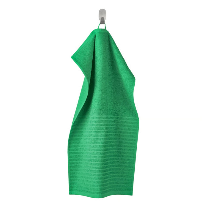 Green dress on a hanger against a white background