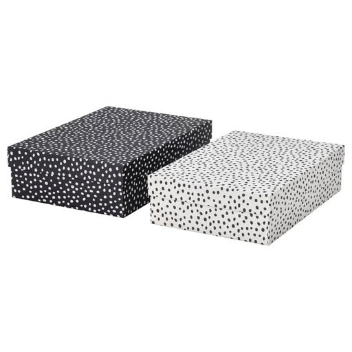 IKEA RÄTTAREN storage box set—includes two rectangular boxes with lids: one black with white polka dots, and one white with black polka dots. Positioned side by side, these visually contrasting boxes offer stylish and functional storage for home or office use – 90597986.
