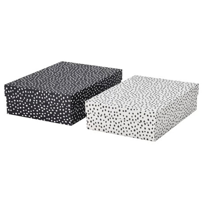 IKEA RÄTTAREN storage box set—includes two rectangular boxes with lids: one black with white polka dots, and one white with black polka dots. Positioned side by side, these visually contrasting boxes offer stylish and functional storage for home or office use – 90597986.
