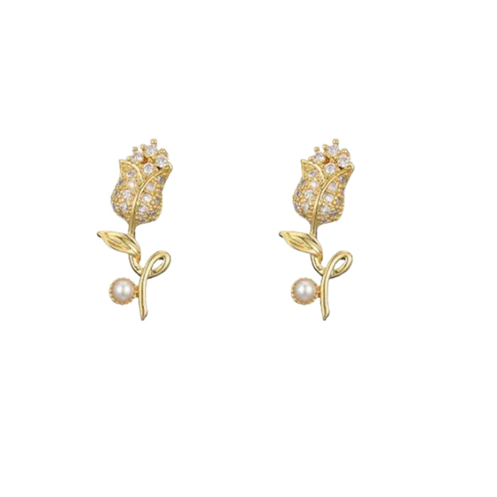 Gold floral earrings with pearl centers on a white background