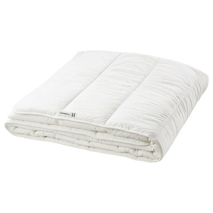 Folded white comforter on a white background