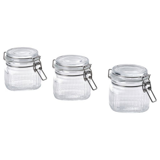 Three clear glass jars with metal clamps on a white background
