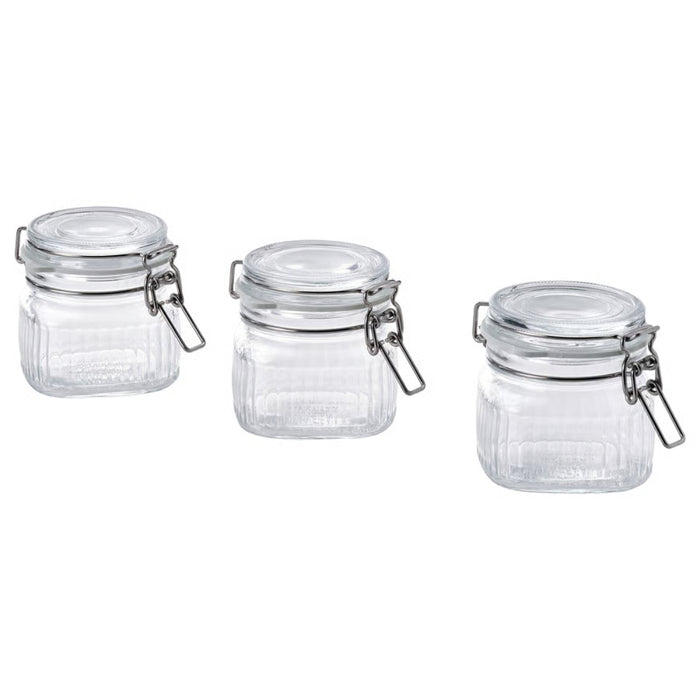 Three clear glass jars with metal clamps on a white background