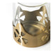 Close-up of the IKEA AROMATISK tealight holder showing the detailed floral cutout pattern on the gold-colored metal base.