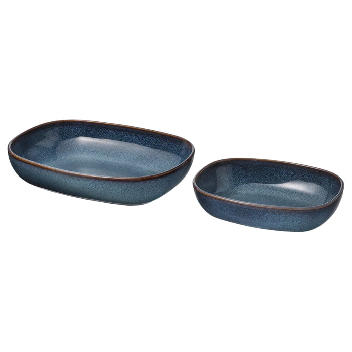 Set of two IKEA GLADELIG oven dishes in rich blue color, featuring rectangular forms with softly rounded edges. The dishes have a smooth, glossy ceramic finish with a darker blue gradient along the rims. The larger and smaller dishes nest together neatly, offering versatility for baking, roasting, or serving. Their elegant design transitions seamlessly from oven to table—perfect for everyday use or stylish dining presentations -20531079.