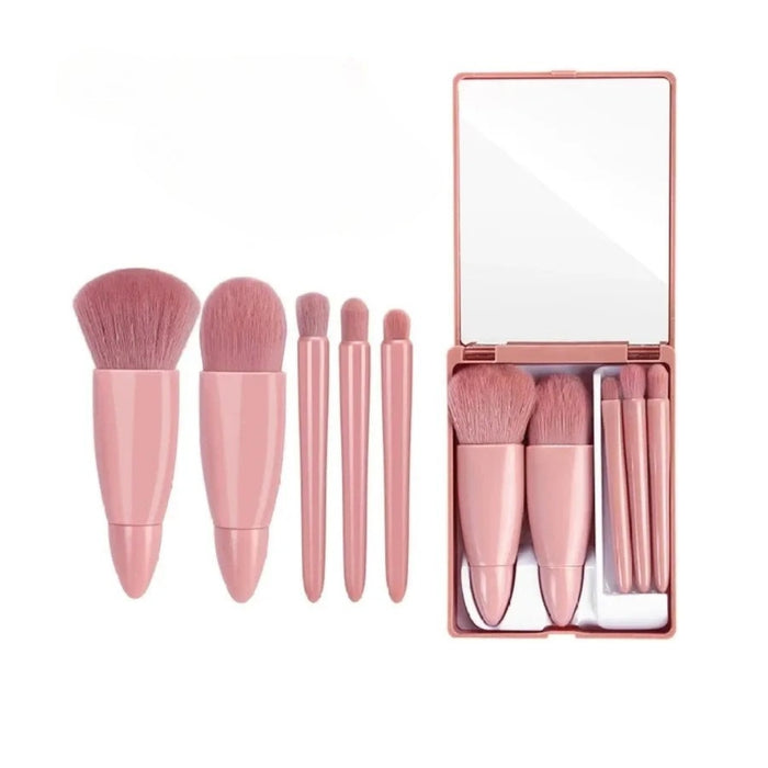 Set of pink makeup brushes with a mirror in a box on a white background